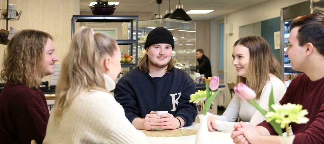 a group of students in a cafe, around a table