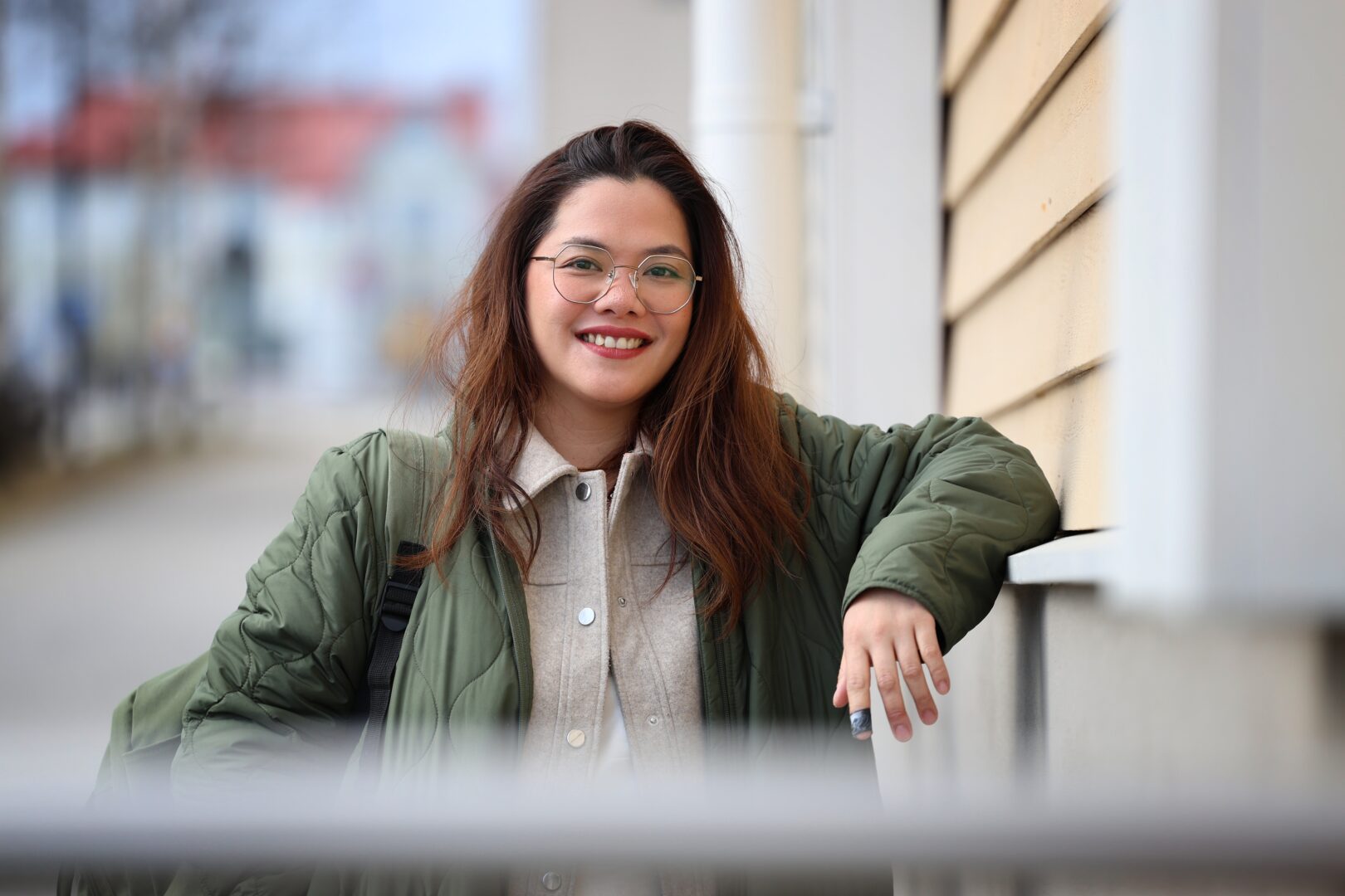 Young woman smiling. She is wearing a green jacket.