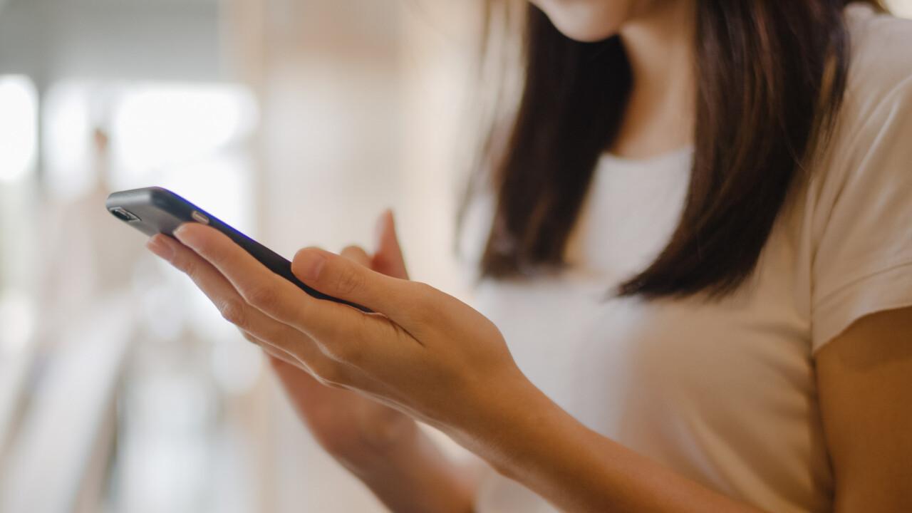 Women using mobile phone at office.