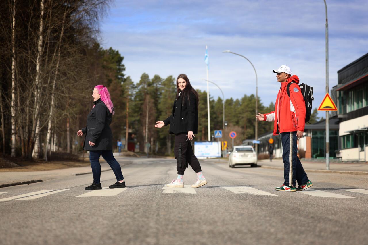 Kolme nuorta kävelemässä suojatien yli