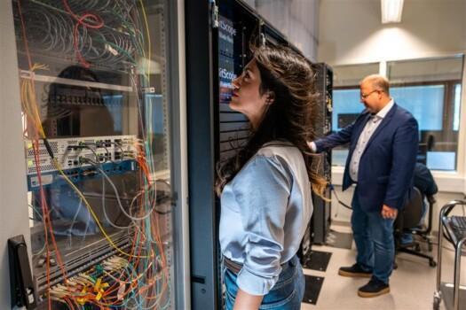 Two people in the KAMK DC lab examining the laboratory's computers and other equipment. Picture: Kajaani University of Applied Sciences.