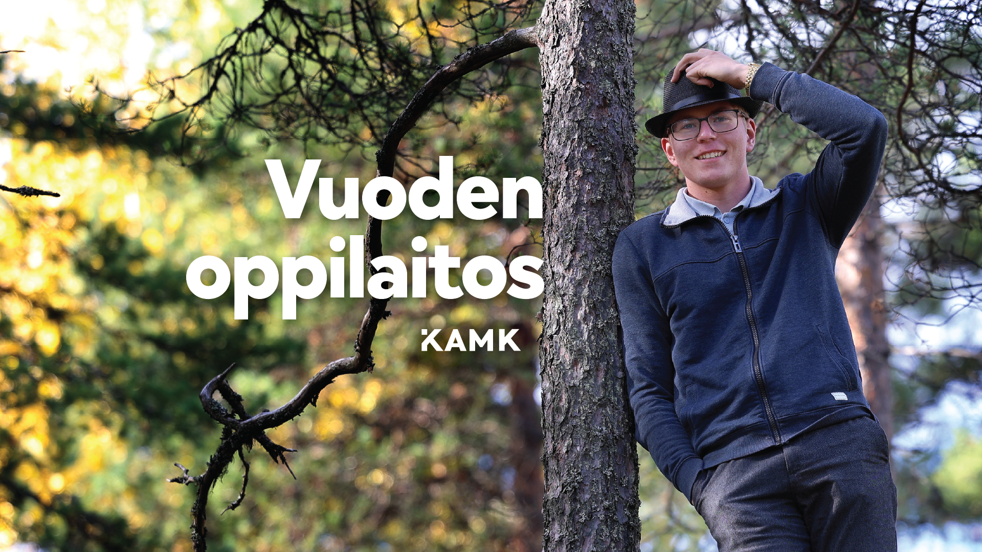 Nuori mies seisoo metsässä kivellä. Kuvassa lukee Vuoden oppilaitos