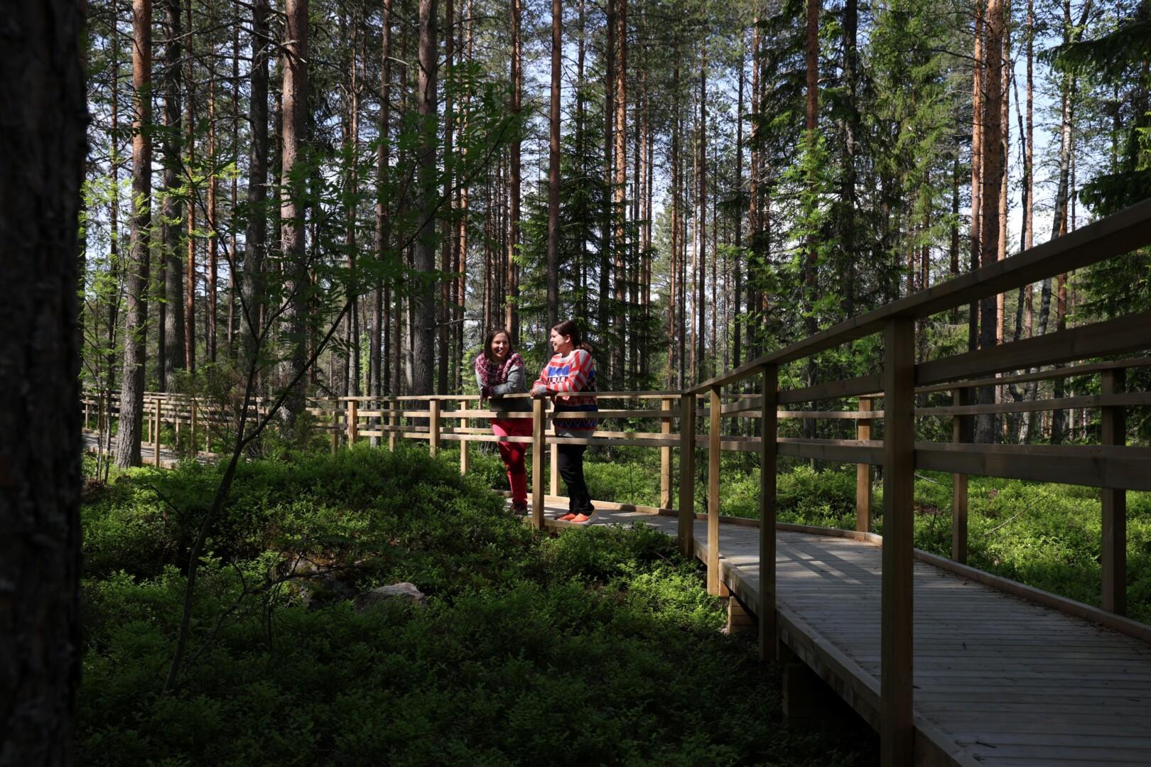 Two people standing in Kajaani's Health Forest route on a summer day.